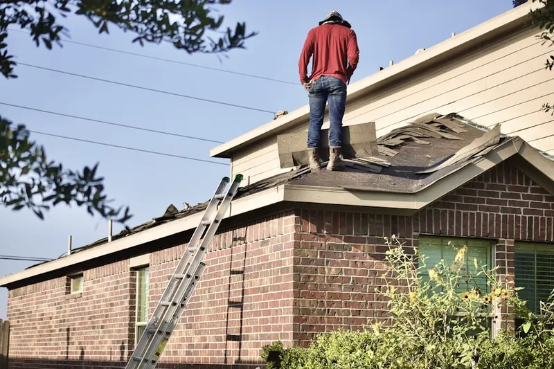 Professional roofer working on a residential roof in Peyton